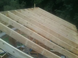 New roof rafters set over an addition before sheathing in Fulton